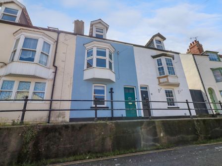 Terraced houses with bay windows and colored doors on a street at 26 High West in Weymouth