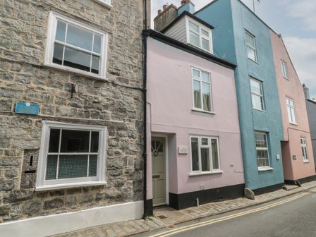 Street view of stone and pastel-colored houses with windows and doors at Lavender Cottage in Lyme Regis