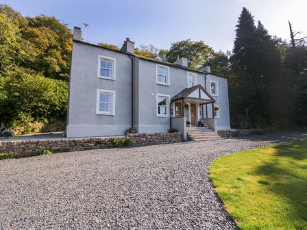 The exterior of a two story grey house with white windows and a gravel driveway at Dalegarth Hall Farm Cottage 2 Boot near Eskdale Green