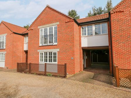 A red brick residential building with white framed windows and a driveway at The Mill Stones in Stalham