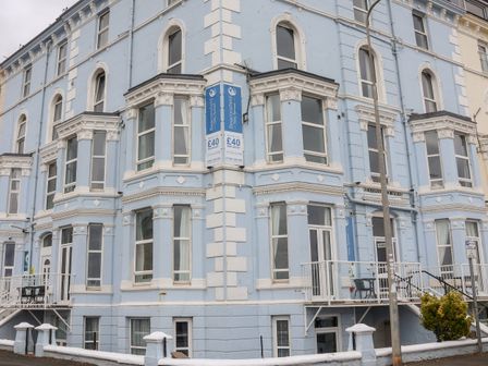 A blue and white corner building with multiple windows and balconies with white railings at Seaside in Bridlington
