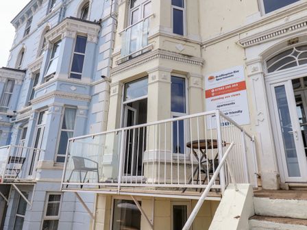 Exterior view of balconies with chairs and tables on a building with Bridlington Bay Apartments sign in Bridlington