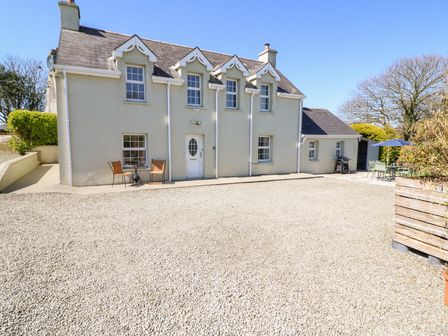 Front view of a two story house with gravel driveway and outdoor seating at Maulnagirra in Leap County Cork