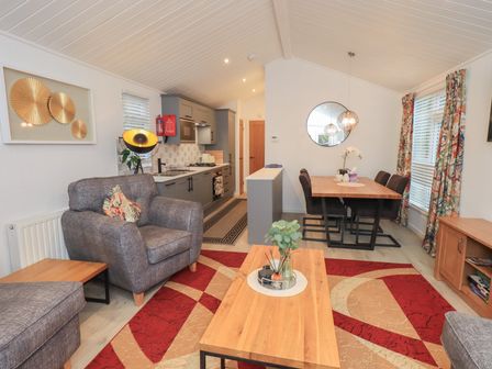 A living room with a sofa and dining area at Merewood in Troutbeck Bridge