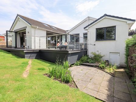 An outdoor area with a deck and garden at Yonder Lea in Bowness-On-Windermere