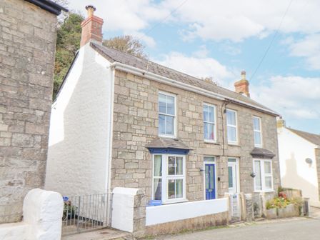 A stone house with blue doors and windows on a street at Crab Pot Cottage in Porthleven