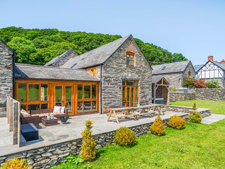 An outdoor space with a house and patio furniture at The Barn in Corwen