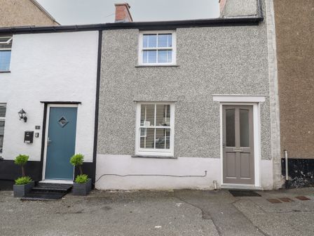 The front of two attached houses with doors and windows on a street at Ty Bach Twt in Conwy