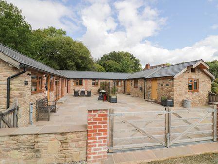 A house with a patio and outdoor furniture at Keepers Barn Bromyard
