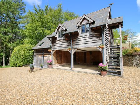 A garage with gravel space and planter at Pultheley Cottage in Hyssington near Churchstoke