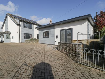 Two modern houses with paved driveway and a stone wall at Aneths Annex in Harrow Hill Drybrook