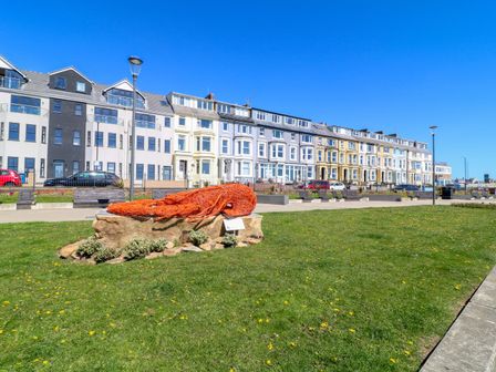 An outdoor area with a sculpture of a lobster and buildings in the background at Apt 6 @ Hunter's Quay, Bridlington