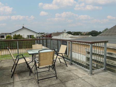 An outdoor seating area with a table and chairs at 6 Gwelfor Estate