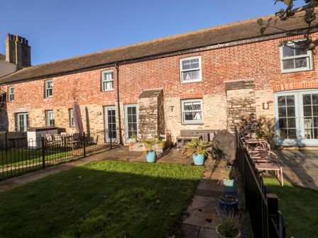 A brick and stone terraced house with patio furniture and potted plants outside at 5 The Old Smokehouse in Charlestown