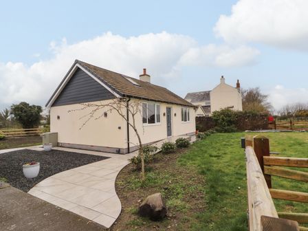 A detached house with tiled roof a paved walkway and garden at Cherry Croft in Bowness-On-Solway
