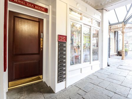 Entrance door with mailboxes next to window display on stone pavement at Royal Oak House in Keswick