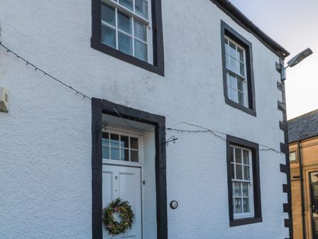 The exterior of a white house with black window and door frames a white door with a wreath and a number 3 on the door and wall at Victoria House in Belford