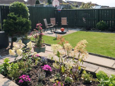 A garden with flower beds lawn chairs a basketball hoop and a basketball at 36 Chatsworth Close Bridlington