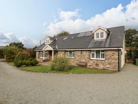 A house with a garden and gravel driveway at Ty Ni in Dyffryn Ardudwy