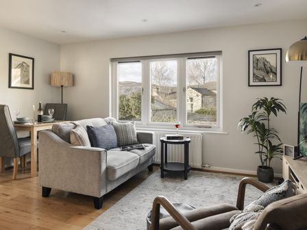 A living room with a sofa and dining table at Rydal Apartment Ambleside in Ambleside