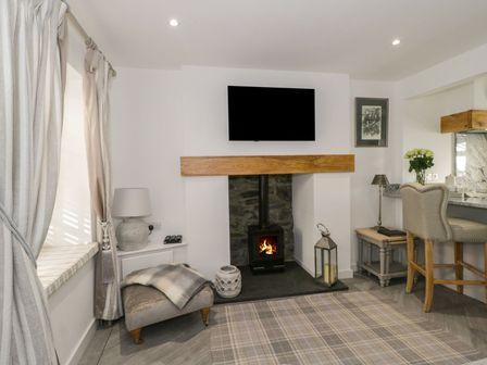 A living room with a fireplace and television above it at 9 Chapel Street in Conwy