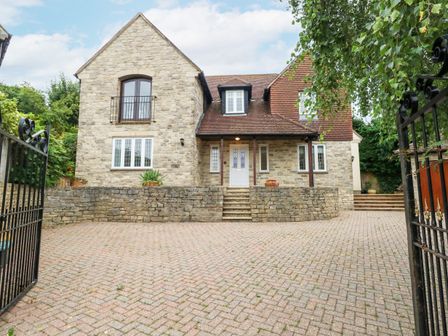 A stone house with a tiled roof and a paved driveway at Sunningdale Rise in Preston