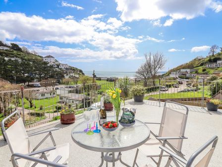An outdoor seating area with a table and chairs at Shells Cottage in Looe
