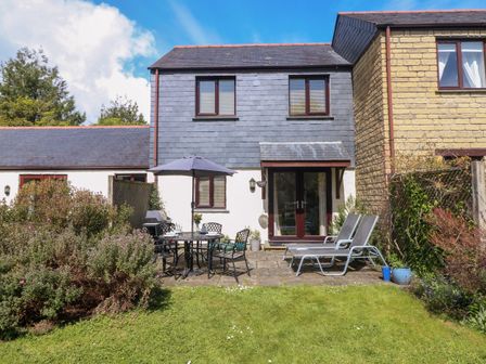 A backyard with garden furniture and plants at Carrick Cottage in Goldenbank near Falmouth