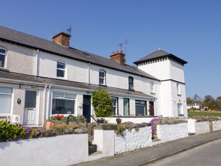 A row of white terraced houses with stone walls and steps along a street at 3 Coastguard Station in Rathmullan County Donegal