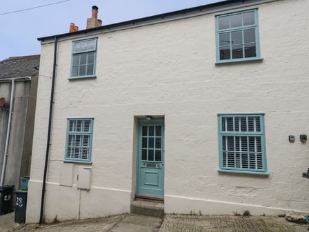 A cream colored two story house with blue window frames and a blue front door at Fisherman's Cottage King Street in Fortuneswell
