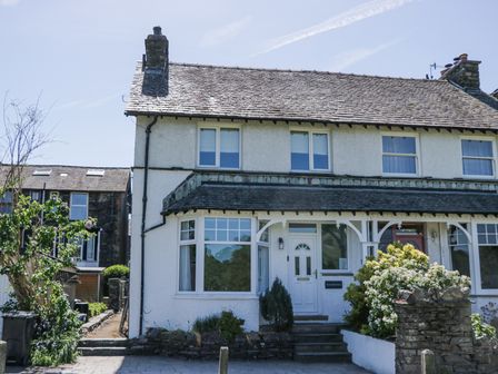 A semi detached house with a front porch and garden at Boundary House in Windermere