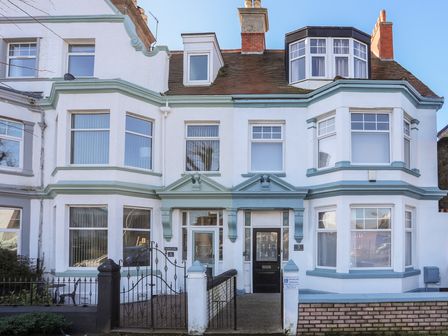 The exterior front view of a two story house with white walls blue trim multiple windows and two entrances at Noah's Rest in Llandudno