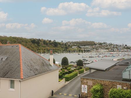 A view of houses trees and parked cars near a marina with boats on the water at 39 Dart Marina Dartmouth