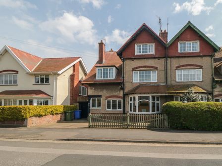 A street view of semi detached houses with picket fences and hedges at 61 West Avenue in Filey
