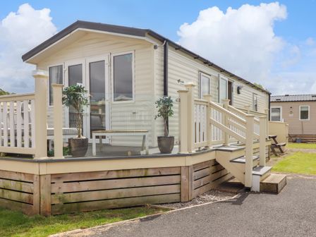 An exterior view of a mobile home with a small porch and steps at Windermere Lodge in Morecambe