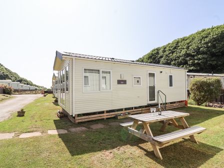 A caravan with a picnic table and glasses at Caravan 7 in Plymouth