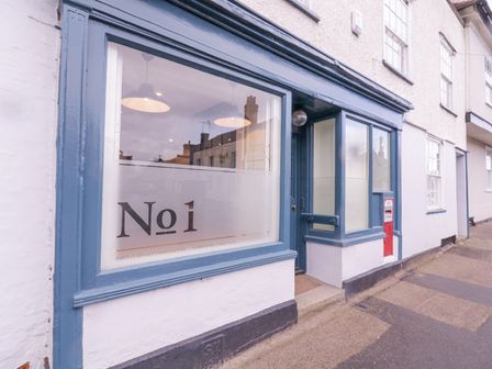 The front of a building with large windows and a blue door with a sign reading No 1 at Number 1 in Clare