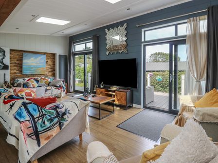 A living room with a sofa and coffee table at Coogee View in Maenygroes near New Quay