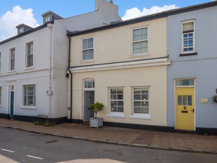 A row of attached houses with doors and windows on a paved street at The Old Greengrocers in Shaldon
