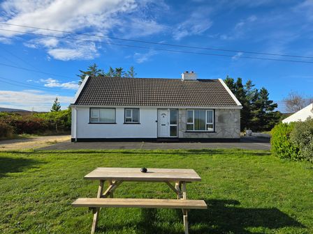 A house with a tiled roof and a picnic table on the lawn at The Island's View in Gortahork County Donegal