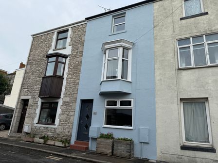 A row of attached houses with different exterior finishes on a street at Home From Home in Fortuneswell