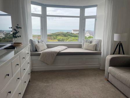 A living room with a window seat and sea view at No.7 Plas Darien in Trearddur Bay