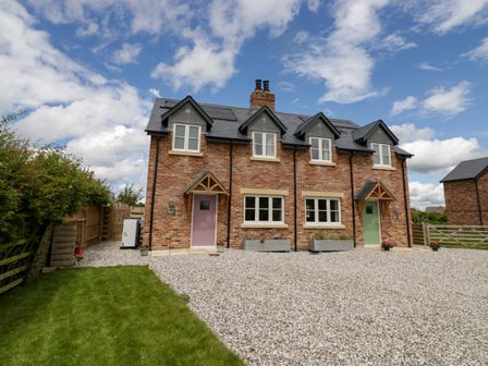 A brick semi detached house with two entrances and gravel driveway at Daisy Cottage in Oxhill near Tysoe