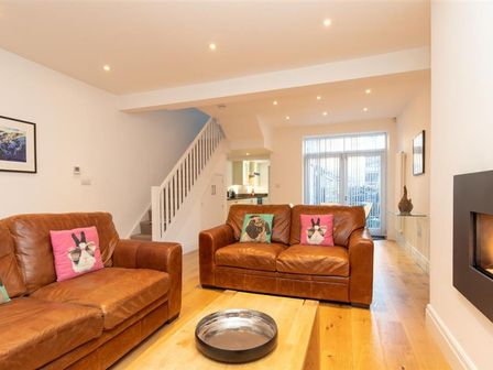 A living room with two brown leather sofas and animal print cushions at Keldas in Ambleside