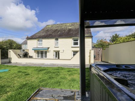 A garden with a house in the background at Station Hall in Cilgerran