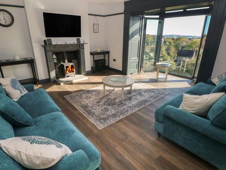 A living room with a fireplace and television at 9 Brython Place in Tenby