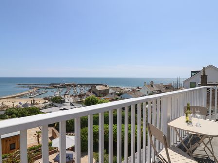 A balcony view overlooking the ocean and harbor at 3 Harbour Heights Lyme Regis