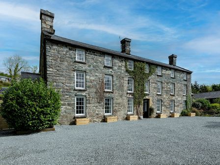 A stone building with windows and a front door at Snowdonia Manor in Dolgellau