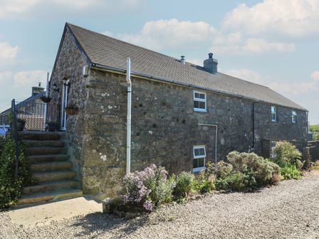 An old stone building with stairs and potted plants outside at Tremornah in Lamorna