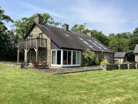 A house with balcony and patio furniture at Bryn Isaf in Ystrad Meurig